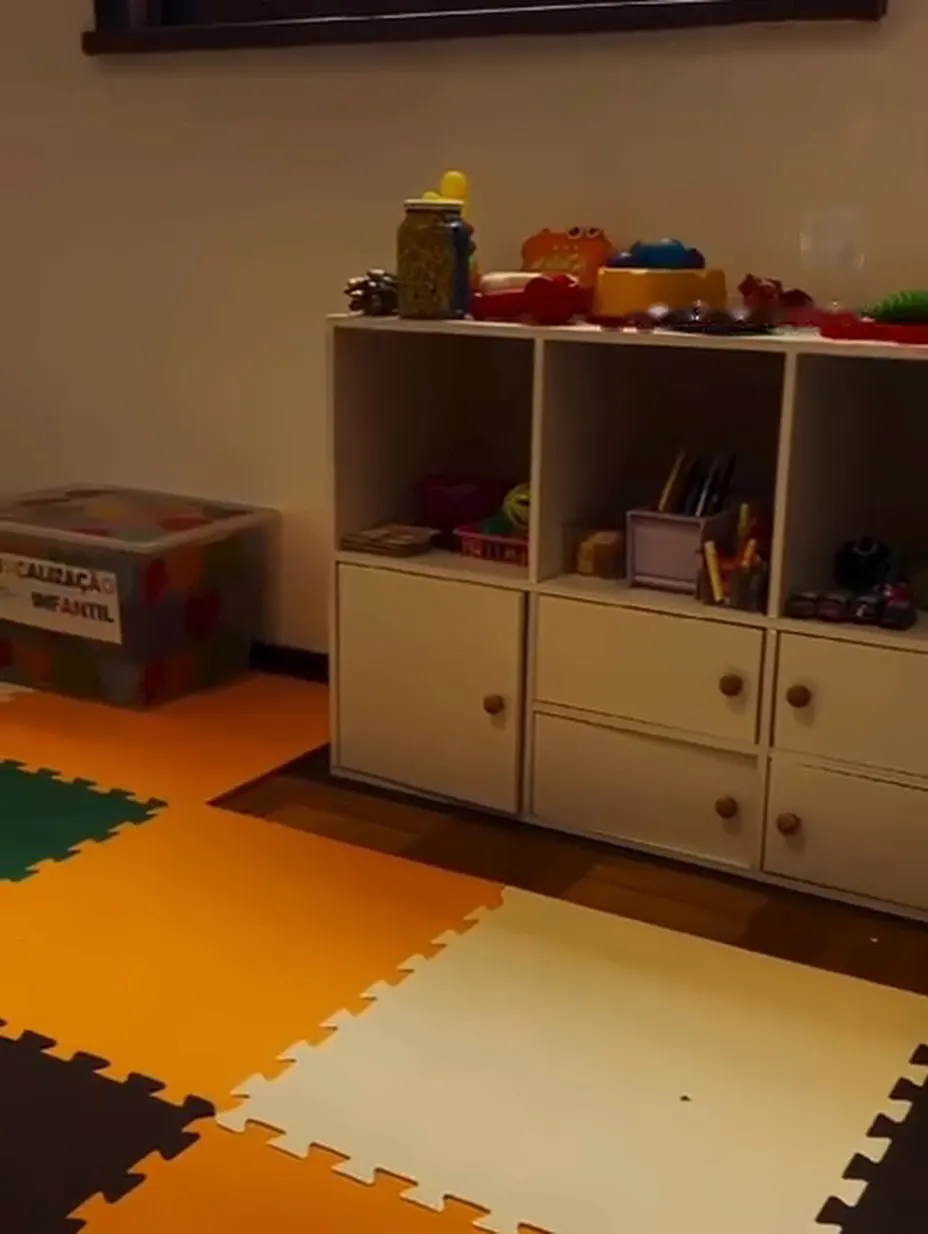 Consultório infantil com brinquedos e piso colorido.